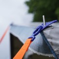 Pas zapinający Tie Strap Peggy Peg zabezpiecza markizę w wietrzną pogodę.